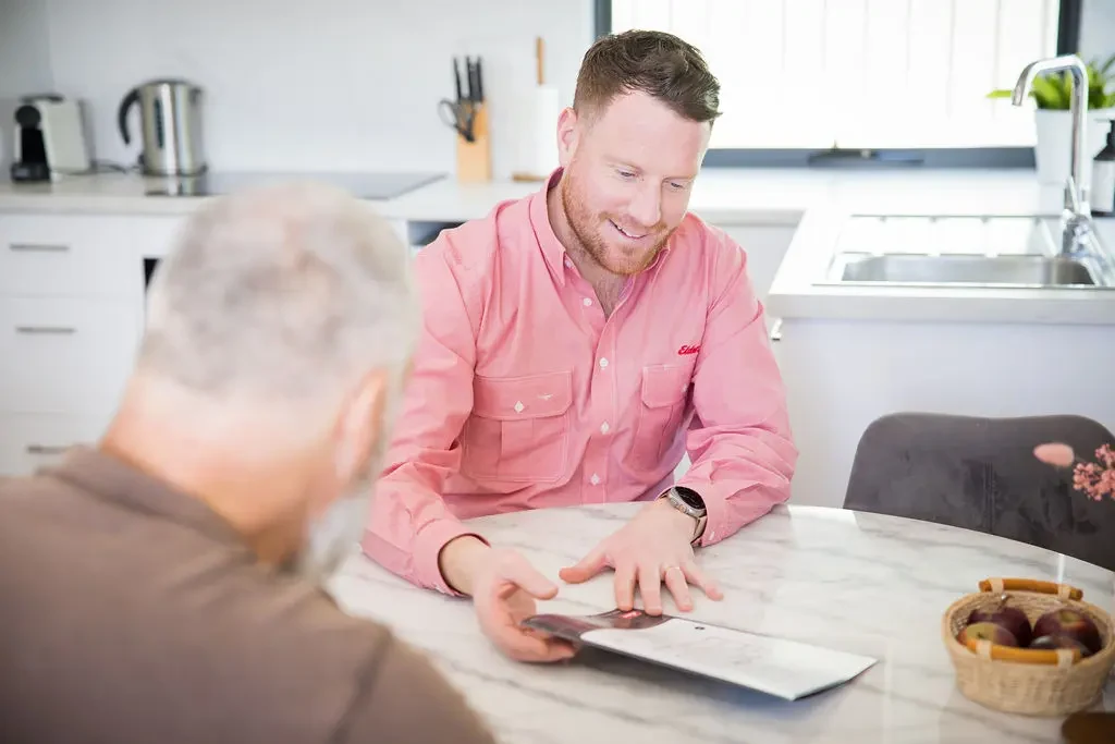 Tommie discussing a property with a client at a kitchen table
